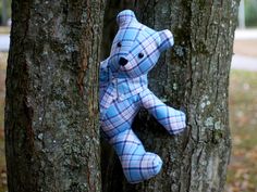 a blue teddy bear sitting on the side of a tree