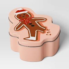 a pink cookie tin with a ginger on it's side and a santa hat on top