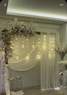 a white wedding arch decorated with flowers and lights for the ceremony room or reception area