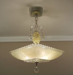 a chandelier hanging from the ceiling in a room with white walls and ceilings