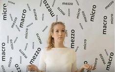 a woman standing in front of a wall with words all over it