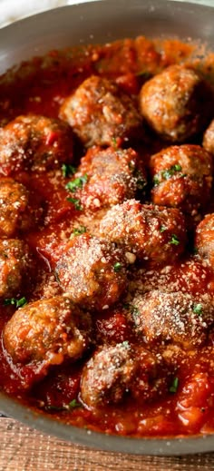 meatballs covered in marinara sauce and parmesan cheese sprinkled on top