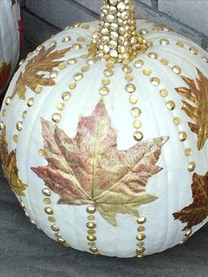 a large white pumpkin decorated with gold leaves