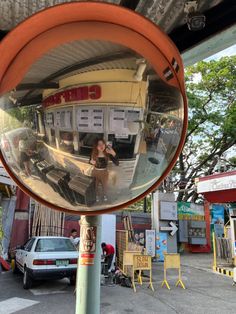 the reflection of a woman sitting on a bench in a mirror at a gas station