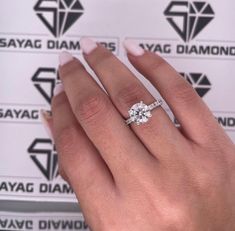 a woman's hand with a diamond ring on top of her finger and two diamonds in the middle