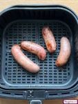 three sausages are being grilled on a grill