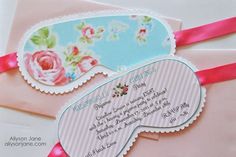 two envelopes with pink ribbon and flowers on them, one has a card attached to it