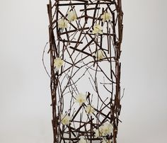 a vase with branches and white flowers on the top is shown in front of a white background