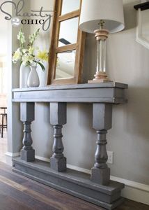 a mirror sitting on top of a wooden shelf next to a vase with flowers in it