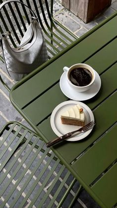 a piece of cake on a plate next to a cup of coffee