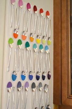 there are many spoons hanging on the wall