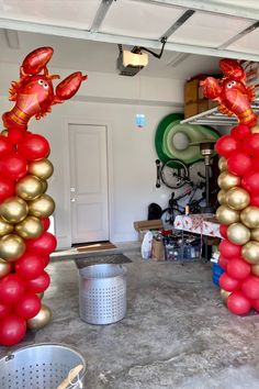 some red and gold balloons in the shape of lobsters are hanging from the ceiling