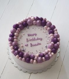 a birthday cake with purple and white frosting