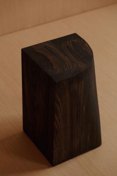 a wooden object sitting on top of a wooden table next to a wall and floor