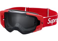 the goggles are red and black with white lettering on them, while one pair of ski goggles sits in front of the goggles