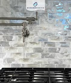 a stove top oven sitting under a faucet next to a wall mounted soap dispenser