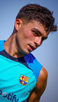 a young man in a blue shirt holding a soccer ball