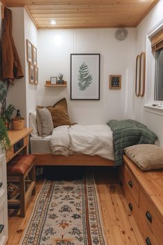 a bedroom with a bed, dressers and rug on the floor in front of it