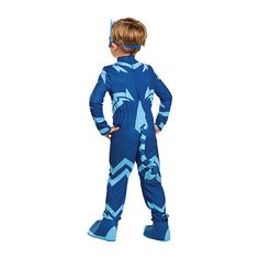 a young boy wearing a blue jumpsuit and goggles, standing in front of a white background