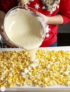 a person pouring batter into a pan filled with popcorn