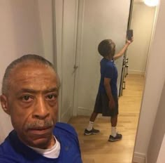 an older man taking a selfie in front of a mirror