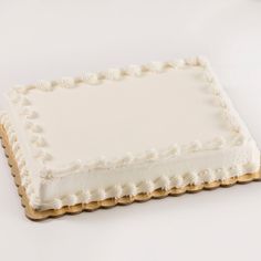 a square cake with white frosting on a table