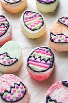 colorful decorated cookies sitting on top of a white table