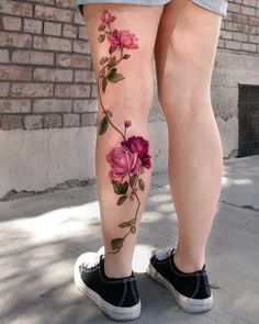 a woman's legs with pink flowers on them and the bottom part of her leg