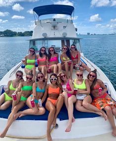 a group of women sitting on the back of a boat posing for a photo together