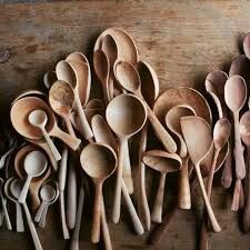 wooden spoons lined up on top of a table next to each other with different shapes and sizes