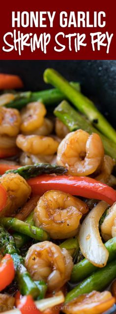 a skillet filled with shrimp, asparagus and carrots in a stir fry