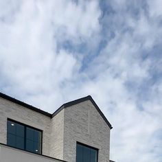 a white building with two windows and a clock on the side