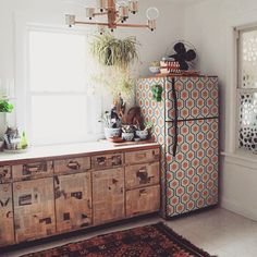 a kitchen with an old fashioned refrigerator and wooden cabinets