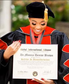 a woman in graduation gown holding up a diploma