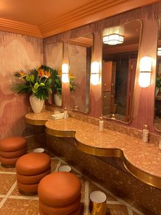 a fancy bathroom with stools and mirrors