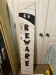 a skateboard with the words beware painted on it in front of a door