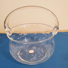 a clear glass bowl sitting on top of a blue table