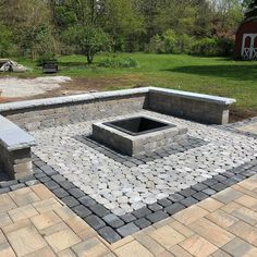 an outdoor fire pit surrounded by stone blocks