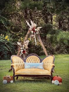 an old fashioned couch sitting on top of a lush green field