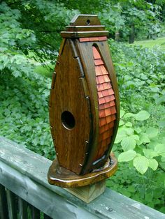 a wooden bird house sitting on top of a fence