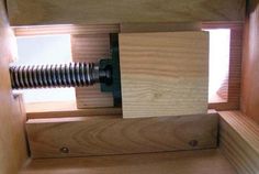 the inside of a wooden box with screws in it