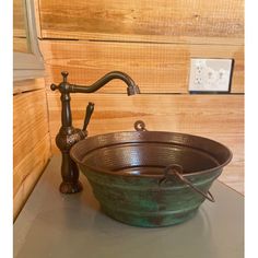 a green bowl sink sitting on top of a counter next to a faucet