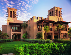 a large building with two towers on top of it's sides in the middle of a lush green field