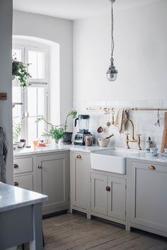 a kitchen filled with lots of white cabinets and counter top space next to a window