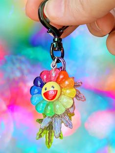 a hand holding a keychain with a colorful flower on it