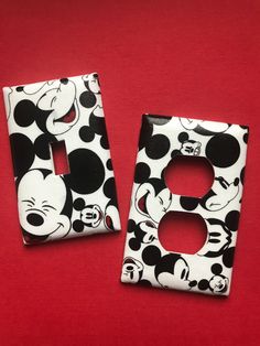 two mickey mouse light switch covers on a red surface