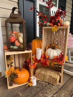 three wooden crates filled with pumpkins and other autumn decorations