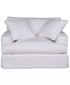 a white couch with two pillows on it and one pillow that is folded over the back