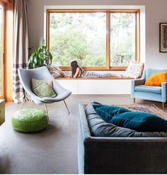 a living room filled with furniture next to a large window covered in windowsills