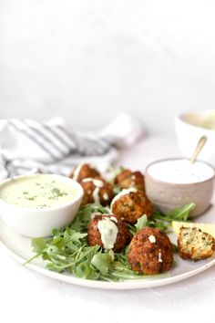 a white plate topped with meatballs covered in sauce and garnished with lettuce